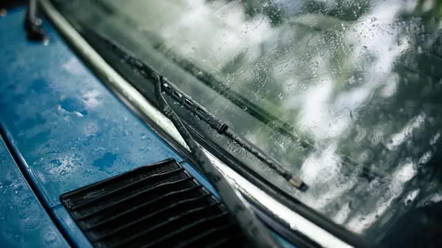 Escobillas limpiaparabrisas apartando la lluvia del parabrisas de un coche